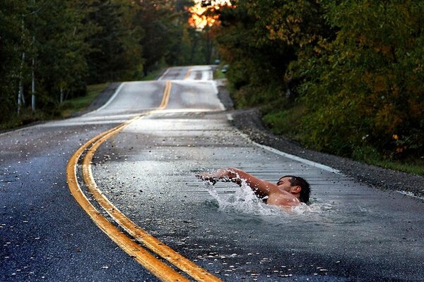 Asphalt road with markings. Swimmer swims