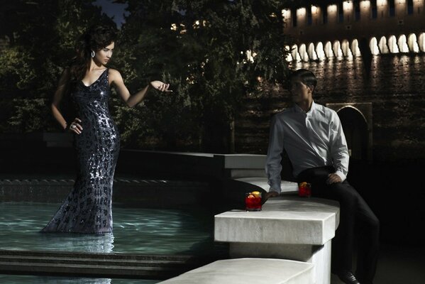 A man and a woman in a fountain. Night