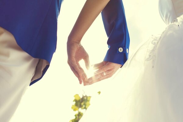 Las manos de la novia y el novio en forma de corazón