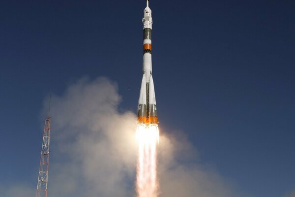 The rocket takes off against the background of a blue cloudless sky