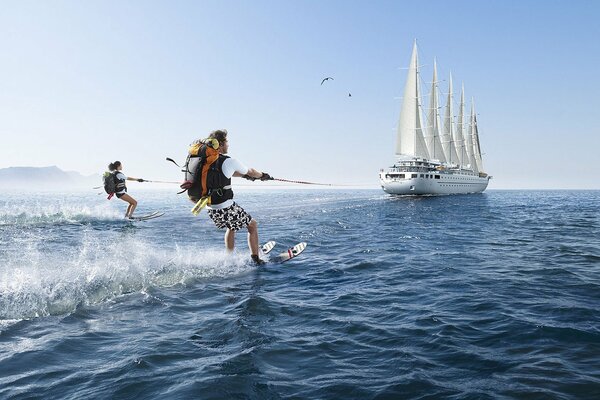 Water skiing in the open sea with a sailboat