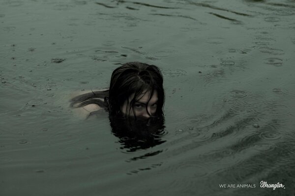 Девушка купается в ночном озере. Над водой торчит только голова