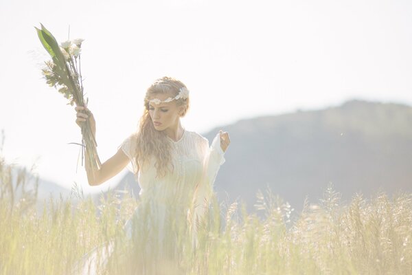 A girl in a white dress collects flowers