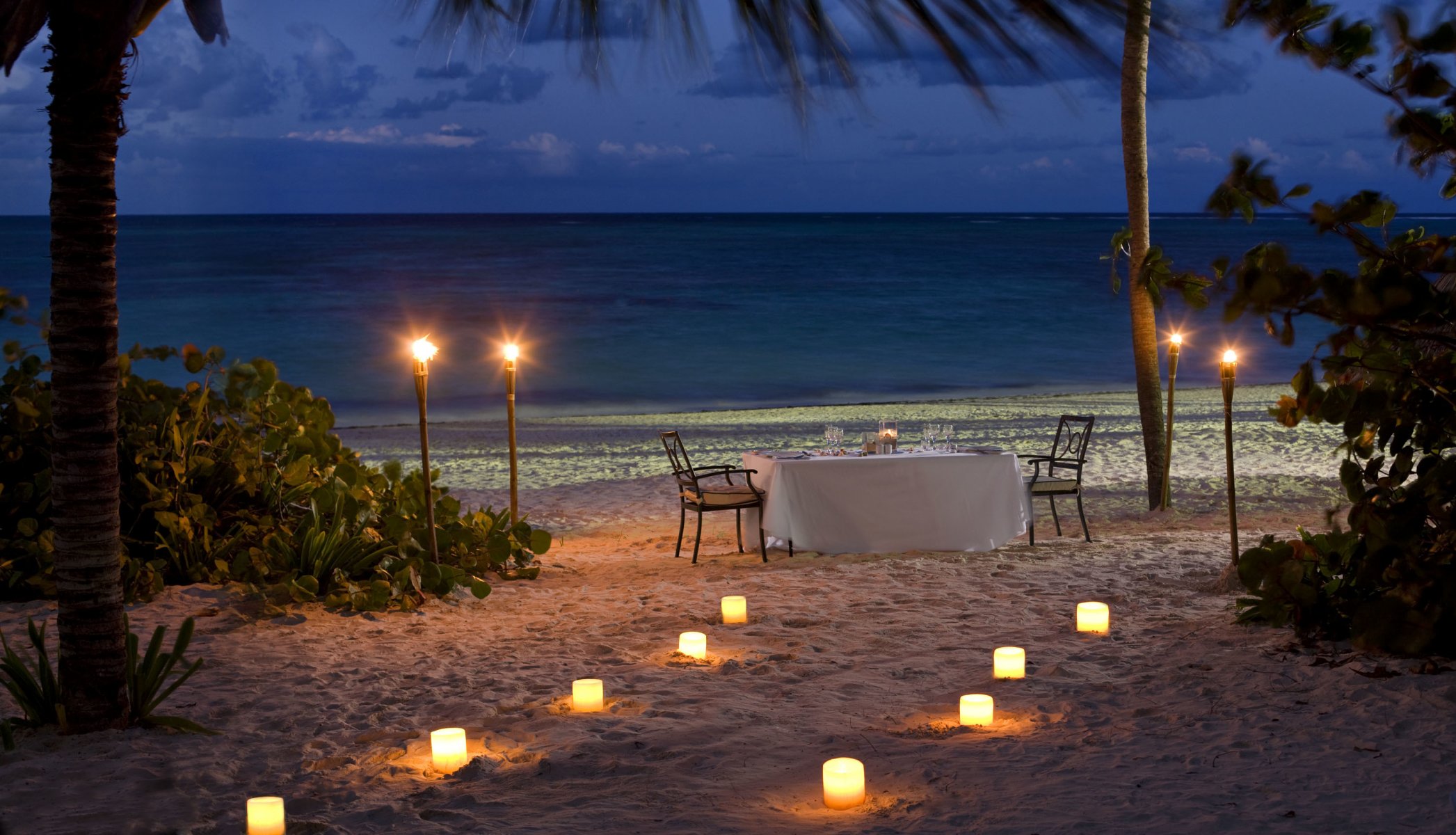 soir plage dîner bougies océan romance coucher de soleil romantique vue