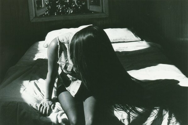 Photo en noir et blanc d une fille assise avec les cheveux longs
