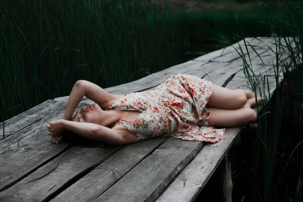 A girl is resting on a bridge over a river