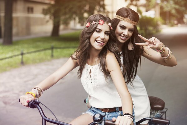Le amiche vanno in bicicletta di buon umore
