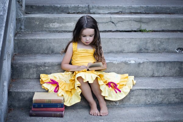 Fille avec des livres est assis sur les escaliers