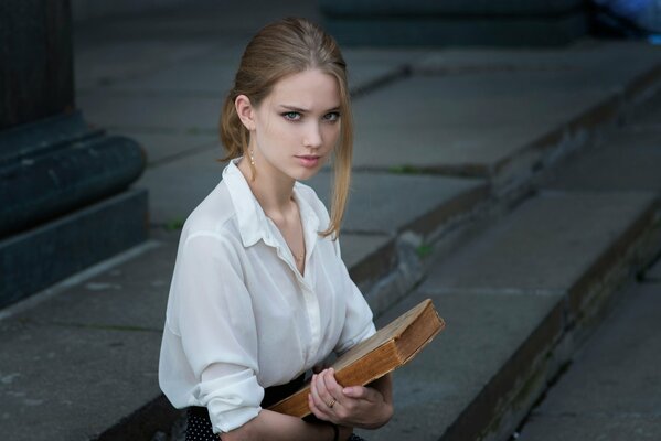 Chica seria con un libro en la mano