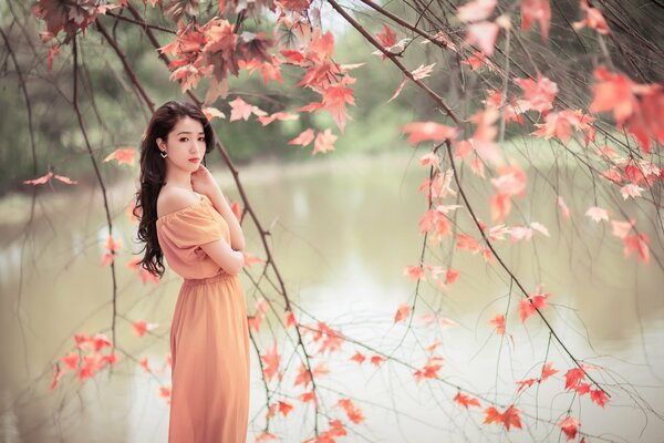 Asiatische Frau in der Natur mit schönen Blättern