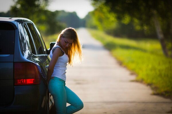 Chica en el coche en el fondo de la carretera