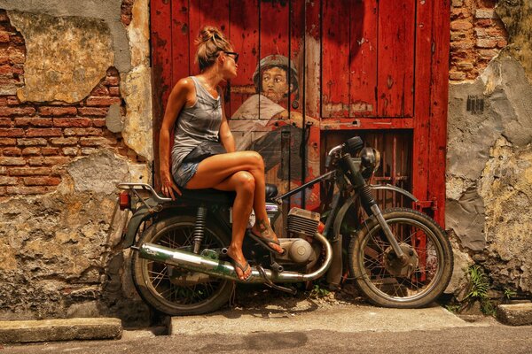 Stadtkunst an der Tür. mädchen auf einem motorrad