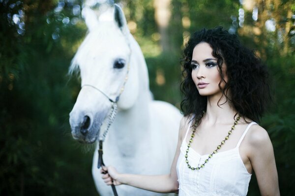 Morena en vestido blanco con caballo blanco