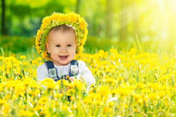 Счастливый малыш на фоне солнечных одуванчиков