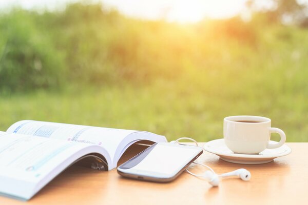 Téléphone livre et tasse sur la table