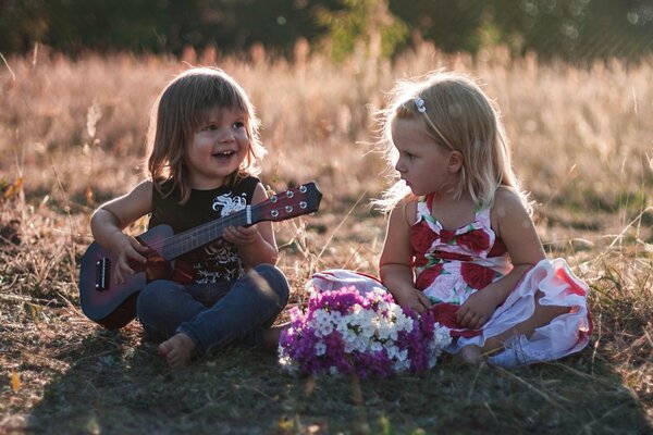 Un niño toca la guitarra y canta para una niña