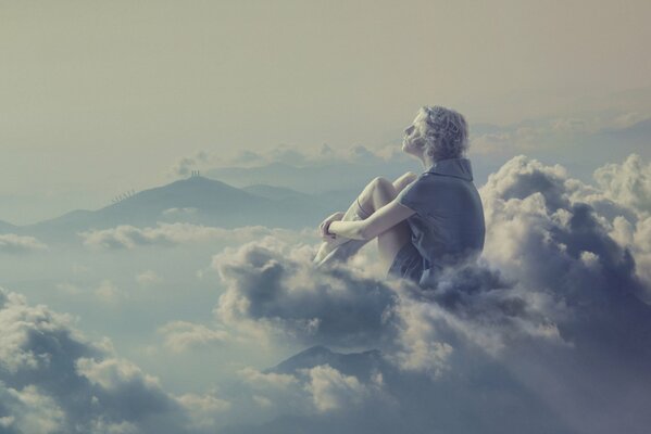 Chica rubia se sienta pensativamente en las nubes
