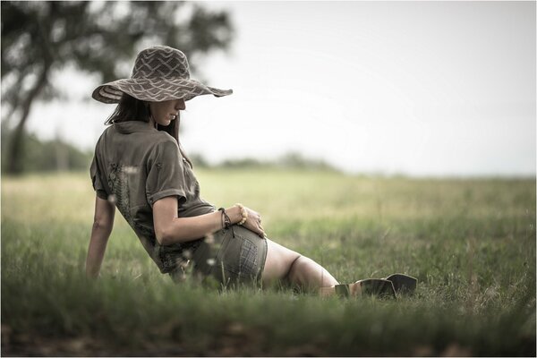 The girl in the hat on the grass