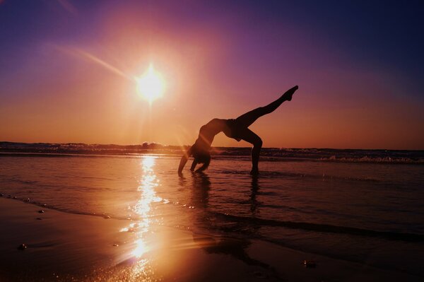 Yoga sur la plage. Coucher de soleil sur la mer