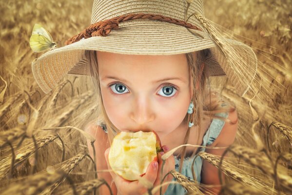 Un bambino mangia una mela in un campo