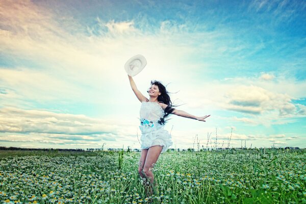 A joyful girl in a field with flowers