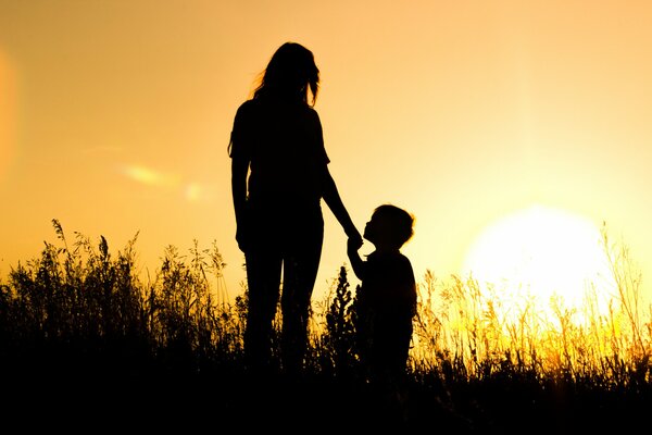 Ragazza con ragazzo nel campo al tramonto