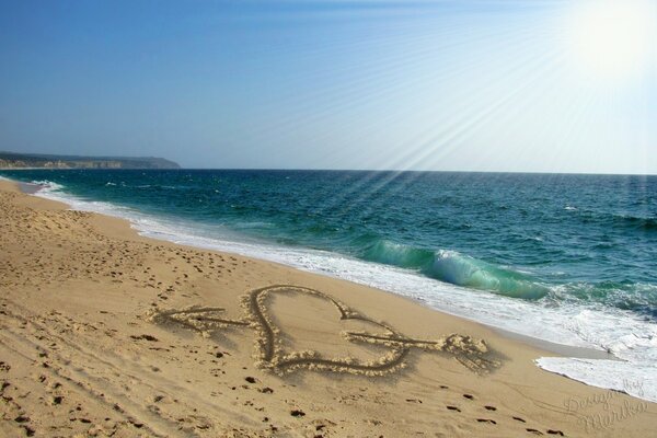 Drawing of a heart on sea sand