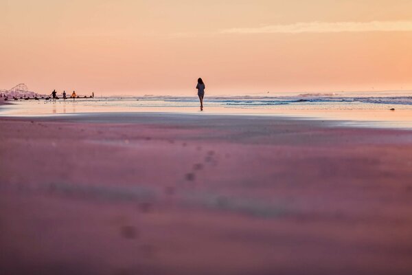 Silhouette eines Mädchens auf dem Sand am Meer