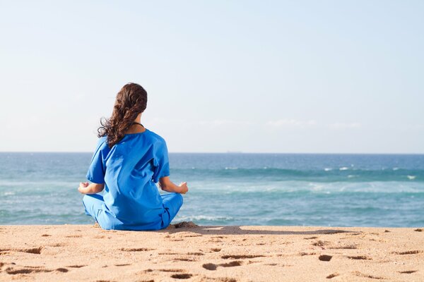 Ragazza rilassante yoga in riva al mare