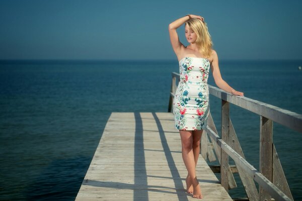 Mädchen im Kleid auf dem Hintergrund des Meeres