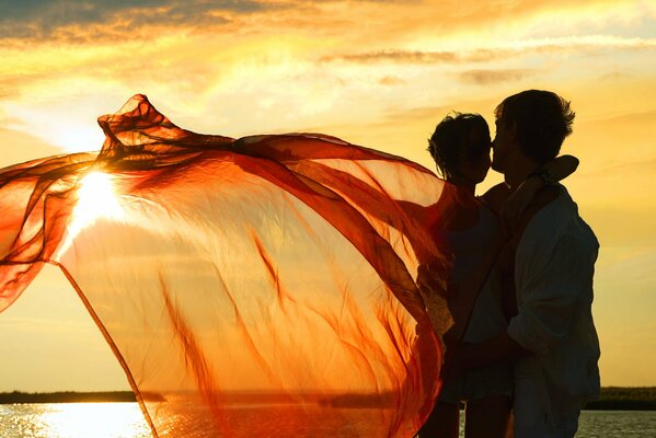 La pareja se acurruca en medio de una puesta de sol en el lago