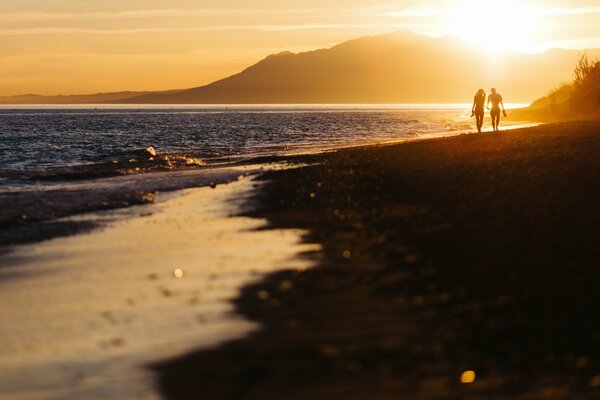 Zwei Liebende treffen den Sonnenuntergang am Strand