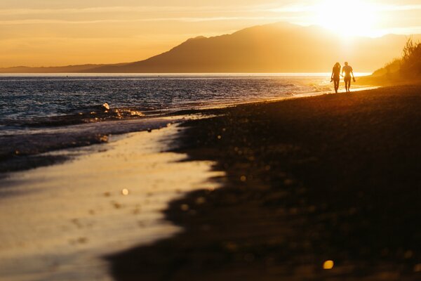 Due amanti incontrano il tramonto sulla spiaggia
