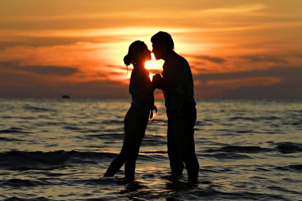 Due amanti nel mare sullo sfondo del tramonto