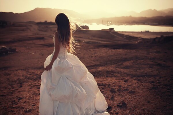 Ragazza in abito da sposa bianco su sfondo stagno