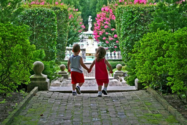A girl and a boy walk along a path in the park