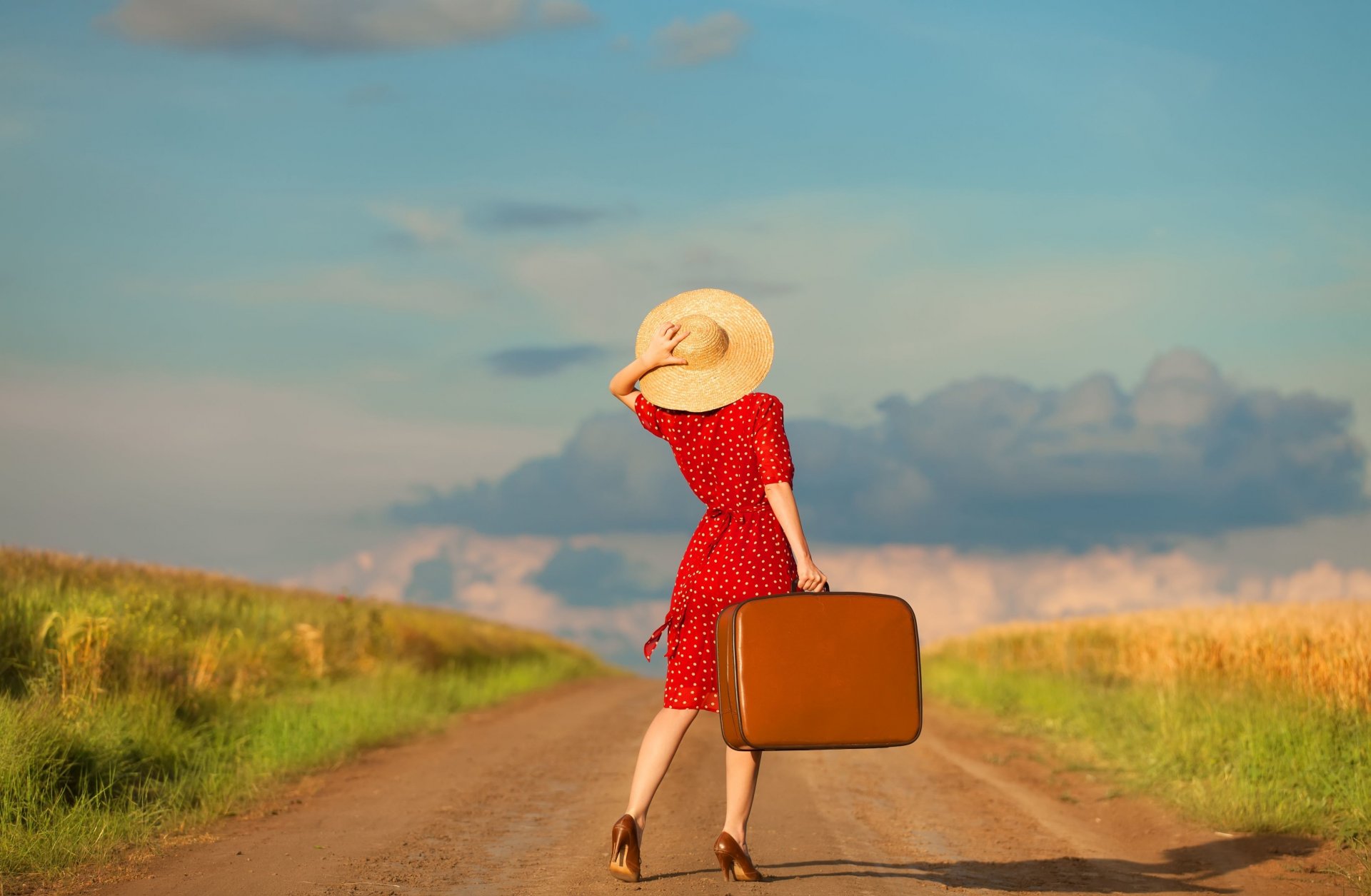 chica vestido sombrero maleta camino cielo nubes