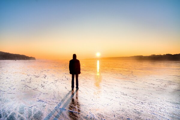 A man on skates admires the sunset