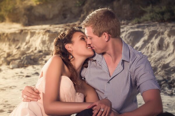 Pareja enamorada sentada en el lago besándose