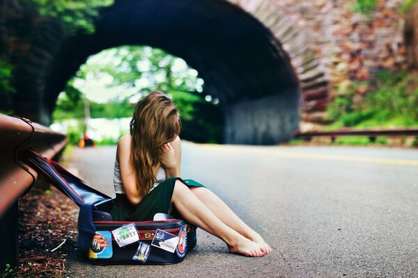 Fille aux pieds nus sur la route en attendant