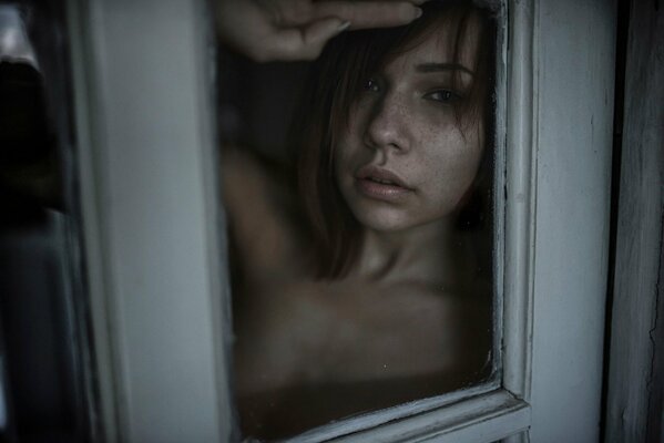 Red-haired girl behind the glass