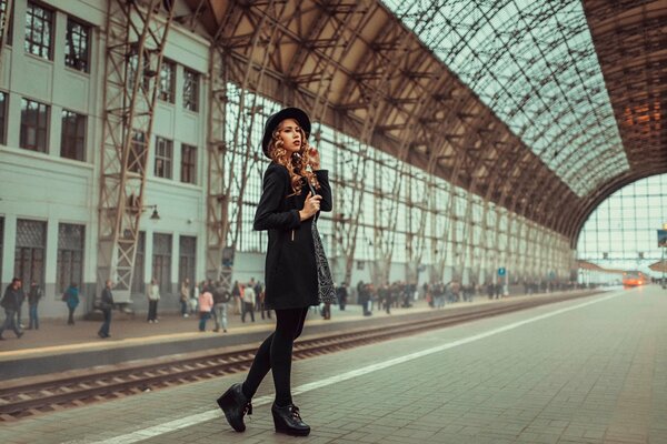 A girl on the platform waiting for a train