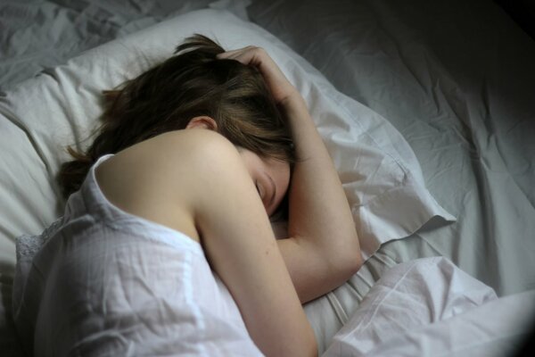 A girl sleeping on a white bed