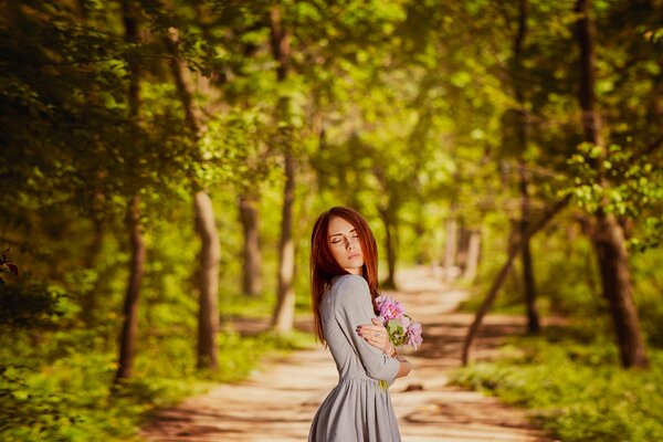 Chica en el callejón con flores en las manos