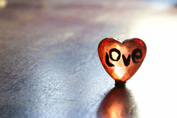 Сердечко с надписью любовь на деревянном столе