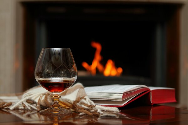 A glass of cognac on the background of a burning fireplace