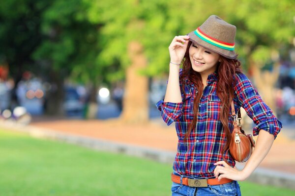 Asiatische Frau mit Hut im Park