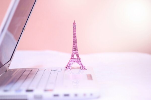 Pink Eiffel Tower statuette on laptop