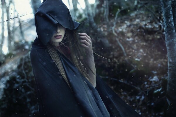 La jeune fille cagoule noire au milieu de la forêt
