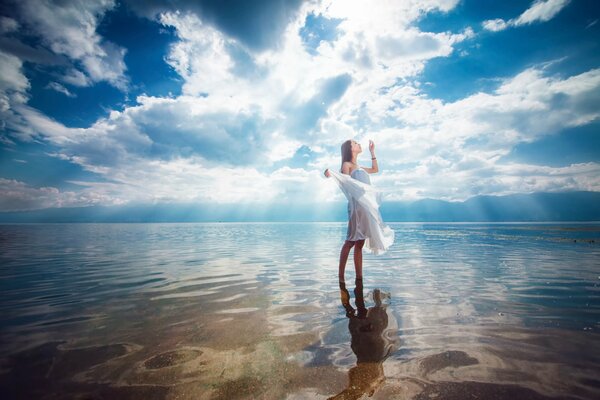 Mädchen am Meer. Klares Wasser. Das Mädchen geht auf dem Wasser. Mysteriöses Foto